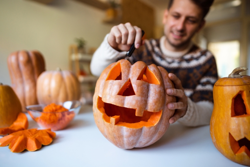 A carver enjoys pumpkin carving—perfect to introduce Guanacaste families to the tradition and spirit of the activity.